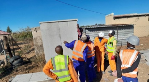 Site crew and community members inspecting completed sanitation infrastructure