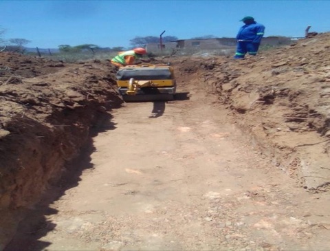 Compaction roller working a trench on a roads project