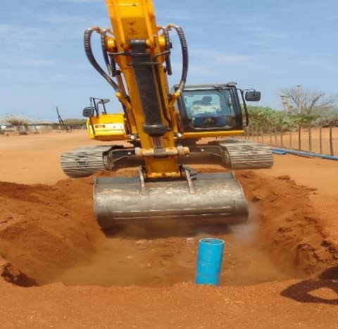 Excavator laying water reticulation pipework